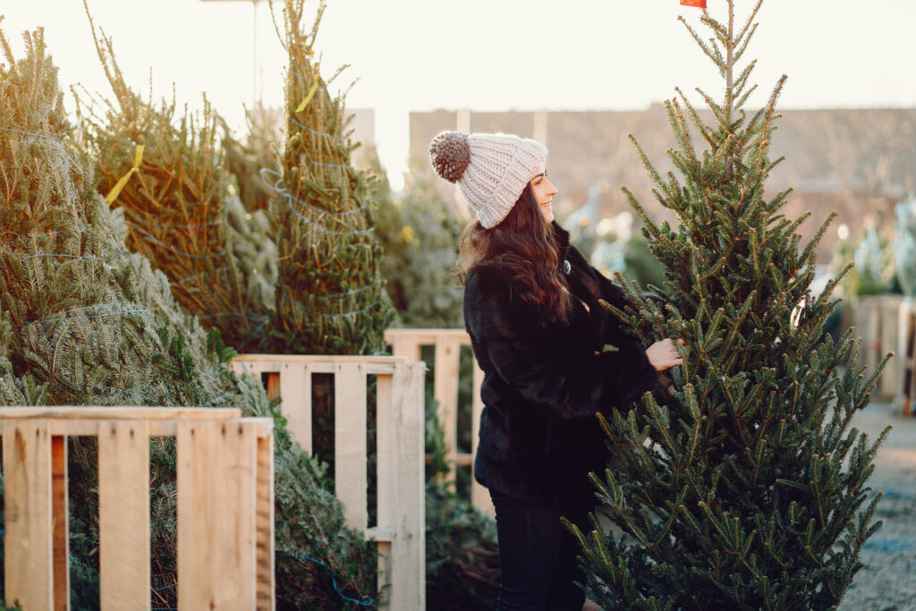 Cute brunette in a white sweater with Christmas tree